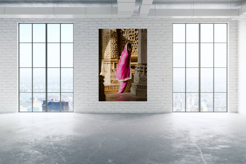 Fotokunstwerk hängt in einem Loft. Abgebildet ist eine Frau in einem pinken Kleid, welche hinter einer alten Seule verschwindet.