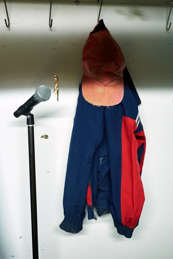 Eine Jacke und ein Cappie hängen am Hacken .Neben ihnen steht ein Mikrophon.