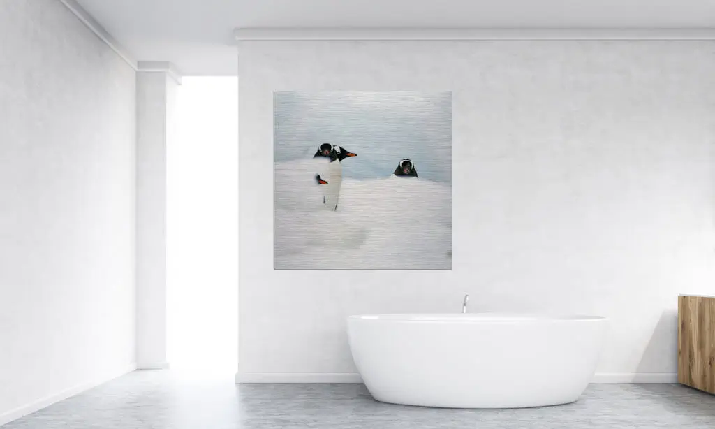 Fotokunstwerk hängt in einem Badezimmer. Abgebildet sind drei Pinguine, welche zur Hälfe von Schnee verdeckt sind.
