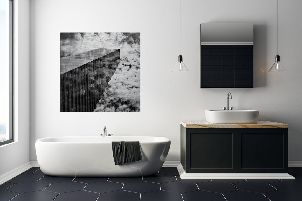 Ein schwarz-weiße Fotokunstwerk hängt in einem Badezimmer. Es bildet einen Wolkenkratzer in der Schweiz ab.