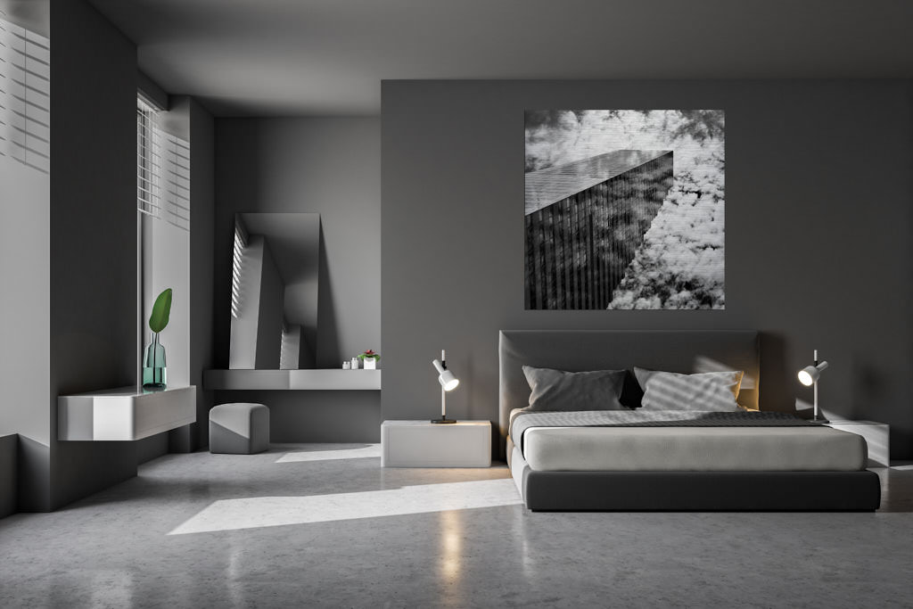 Ein schwarz-weiße Fotokunstwerk hängt in einem Schlafzimmer. Es bildet einen Wolkenkratzer in der Schweiz ab.