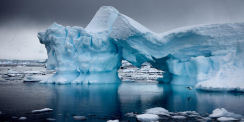 Ein Fotokunstwerk eines Eisberges, welcher in der Mitte zusammenbricht.